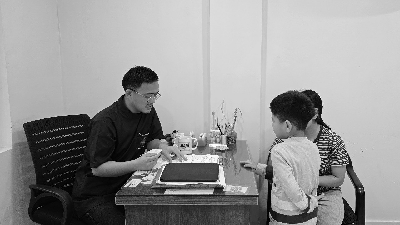 A dentist consulting a young patient at Olive Dental